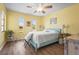 Light-filled bedroom with hardwood floors, with a ceiling fan, and three windows offering natural light at 18399 Burkholder Cir, Port Charlotte, FL 33948