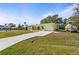 Charming yellow home featuring a concrete driveway, and an attached garage at 18399 Burkholder Cir, Port Charlotte, FL 33948