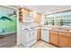 Bright kitchen features wood cabinets, a built-in microwave, and updated appliances at 18399 Burkholder Cir, Port Charlotte, FL 33948