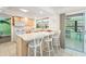 Open kitchen with white countertop seating, tile floors, and sliding door access to an outdoor space at 18399 Burkholder Cir, Port Charlotte, FL 33948