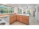 Bright kitchen features wood cabinets, a double sink under a large window, and a dining area at 18399 Burkholder Cir, Port Charlotte, FL 33948