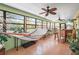 Relaxing sunroom/porch featuring a hammock, bar with seating, ceiling fans, and lots of windows at 18399 Burkholder Cir, Port Charlotte, FL 33948