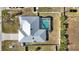 Aerial view of fenced property featuring a screened pool, well-maintained landscaping, and mature trees at 19990 Midway Blvd, Port Charlotte, FL 33948