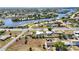 Aerial view of a neighborhood with waterfront access, showcasing beautiful homes with pools and landscaping at 19990 Midway Blvd, Port Charlotte, FL 33948