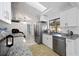 This kitchen has a skylight, white cabinets, stainless appliances, granite countertops, and modern lighting at 19990 Midway Blvd, Port Charlotte, FL 33948
