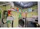 Green laundry room with wire shelving and modern, stainless steel washer and dryer at 19990 Midway Blvd, Port Charlotte, FL 33948