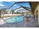 Outdoor pool and hot tub featuring a screened in enclosure, tile flooring, and lighting at 19990 Midway Blvd, Port Charlotte, FL 33948