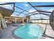 Outdoor pool and hot tub featuring a screened in enclosure, exterior bar, and tile flooring at 19990 Midway Blvd, Port Charlotte, FL 33948