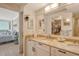 Bright bathroom with double vanity, granite countertops, and a peek into the bedroom and ocean view at 20 Whispering Sands Dr # 406, Sarasota, FL 34242