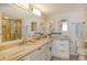 Bathroom with a double sink vanity featuring granite countertops, elegant fixtures, and ample storage space at 20 Whispering Sands Dr # 406, Sarasota, FL 34242