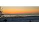 Panoramic beach view with sunset colors, calm ocean, and palm trees for a tranquil coastal experience at 20 Whispering Sands Dr # 406, Sarasota, FL 34242