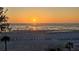 Golden hour beach with calm ocean, and silhouettes of palm trees, and people enjoying the sunset at 20 Whispering Sands Dr # 406, Sarasota, FL 34242