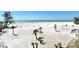 Expansive beach view showcasing sugar-white sand, palm trees, and the Gulf's turquoise waters at 20 Whispering Sands Dr # 406, Sarasota, FL 34242