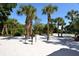 Sandy park area with grills and picnic benches under the palm trees at 20 Whispering Sands Dr # 406, Sarasota, FL 34242