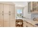 Bright kitchen featuring white cabinetry, granite counters, and a cozy desk area with outside views at 20 Whispering Sands Dr # 406, Sarasota, FL 34242