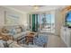 Cozy living room with a large window, comfortable furniture, and ocean views, bathed in natural light at 20 Whispering Sands Dr # 406, Sarasota, FL 34242