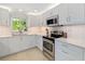 Bright kitchen with white cabinets, stainless steel appliances, and stylish backsplash at 2610 Jefferson Cir, Sarasota, FL 34239