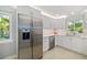 Modern kitchen featuring stainless steel refrigerator, quartz countertops, and sleek white cabinetry at 2610 Jefferson Cir, Sarasota, FL 34239