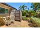 Private outdoor shower surrounded by tropical plants and a quaint wicker chair on a paver patio at 2610 Jefferson Cir, Sarasota, FL 34239