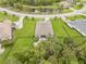 Aerial view of the backyard featuring a landscaped patio with manicured lawn surrounded by trees at 2707 162Nd E Ave, Parrish, FL 34219
