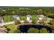 Aerial view of homes in a wooded community, showcasing the landscaped yards and neighborhood pond at 2707 162Nd E Ave, Parrish, FL 34219