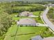 Aerial view of a property with green lawns, trees, and a home with an extended driveway and backyard at 2707 162Nd E Ave, Parrish, FL 34219
