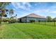 Expansive, grassy backyard surrounded by lush landscaping, fencing, and mature shade trees at 2707 162Nd E Ave, Parrish, FL 34219