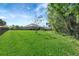 Large backyard with lush green grass, privacy fence, and mature trees providing a serene outdoor space at 2707 162Nd E Ave, Parrish, FL 34219