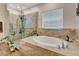 Bright bathroom featuring a soaking tub, glass-enclosed shower and neutral tile at 2707 162Nd E Ave, Parrish, FL 34219