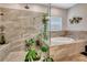 A bright bathroom boasts an expansive shower, soaking tub, and tile surround, with plants at 2707 162Nd E Ave, Parrish, FL 34219