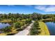 Picturesque gated entrance leading to a community with ponds and lush landscaping, offering privacy and scenic beauty at 2707 162Nd E Ave, Parrish, FL 34219