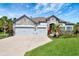 Charming home with a three-car garage, stone accents, manicured lawn, and colorful landscaping at 2707 162Nd E Ave, Parrish, FL 34219