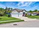 Beautiful home featuring a stone facade, three-car garage, manicured lawn and vibrant tropical landscaping at 2707 162Nd E Ave, Parrish, FL 34219