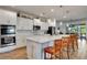 Modern kitchen featuring a spacious island with seating, stainless steel appliances, and stylish pendant lighting at 2707 162Nd E Ave, Parrish, FL 34219