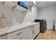 Well-organized laundry room with white cabinets, countertop space, modern washer and dryer, and wood-look tile flooring at 2707 162Nd E Ave, Parrish, FL 34219