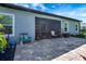 Screened patio with brick pavers, chair, flower pots, and view of backyard at 2707 162Nd E Ave, Parrish, FL 34219