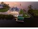 Sunset aerial view of home with private boat dock, lush lawn, and waterfront location at 327 Riverpoint Ne Dr, Bradenton, FL 34208