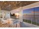 A covered balcony with sunset water views, a modern railing, and outdoor seating at 327 Riverpoint Ne Dr, Bradenton, FL 34208