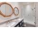 Bathroom featuring double sink vanity with marble countertops and a walk-in shower at 327 Riverpoint Ne Dr, Bradenton, FL 34208