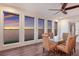 Waterfront dining area with large windows, ceiling fan, and wicker chairs at 327 Riverpoint Ne Dr, Bradenton, FL 34208