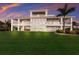 Spacious waterfront property featuring a large lawn, multi-level balconies, and serene water views at 327 Riverpoint Ne Dr, Bradenton, FL 34208