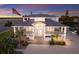 Stunning waterfront home featuring multiple balconies, a metal roof, and ample parking, all set against a colorful sunset at 327 Riverpoint Ne Dr, Bradenton, FL 34208