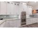 Modern kitchen with stainless steel appliances, granite countertops, tiled backsplash, and custom cabinetry at 327 Riverpoint Ne Dr, Bradenton, FL 34208