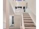 Staircase with wood stairs, white risers, and modern glass railing at 327 Riverpoint Ne Dr, Bradenton, FL 34208