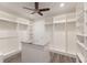 Spacious walk-in closet features custom shelving, hanging rods, drawers and a center island at 327 Riverpoint Ne Dr, Bradenton, FL 34208