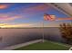 Stunning waterfront view featuring an American flag and beautiful sunset over the water at 327 Riverpoint Ne Dr, Bradenton, FL 34208