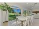 Bright dining area with natural light, modern white table and chairs, and beautiful lawn views at 3320 Hadfield Greene # 39, Sarasota, FL 34235