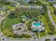Aerial view of the community pool, sports fields, playground and gathering area with mature trees at 3520 Woodmont Dr, Parrish, FL 34219