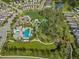 Aerial view of the community with a pool, amenity center, lush landscaping, and well-maintained streets at 3520 Woodmont Dr, Parrish, FL 34219