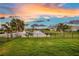 Expansive backyard view with lush green grass, a secure fence, and a serene lake backdrop at 3520 Woodmont Dr, Parrish, FL 34219